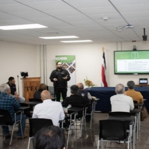 A person standing in front of a group of people

Description automatically generated